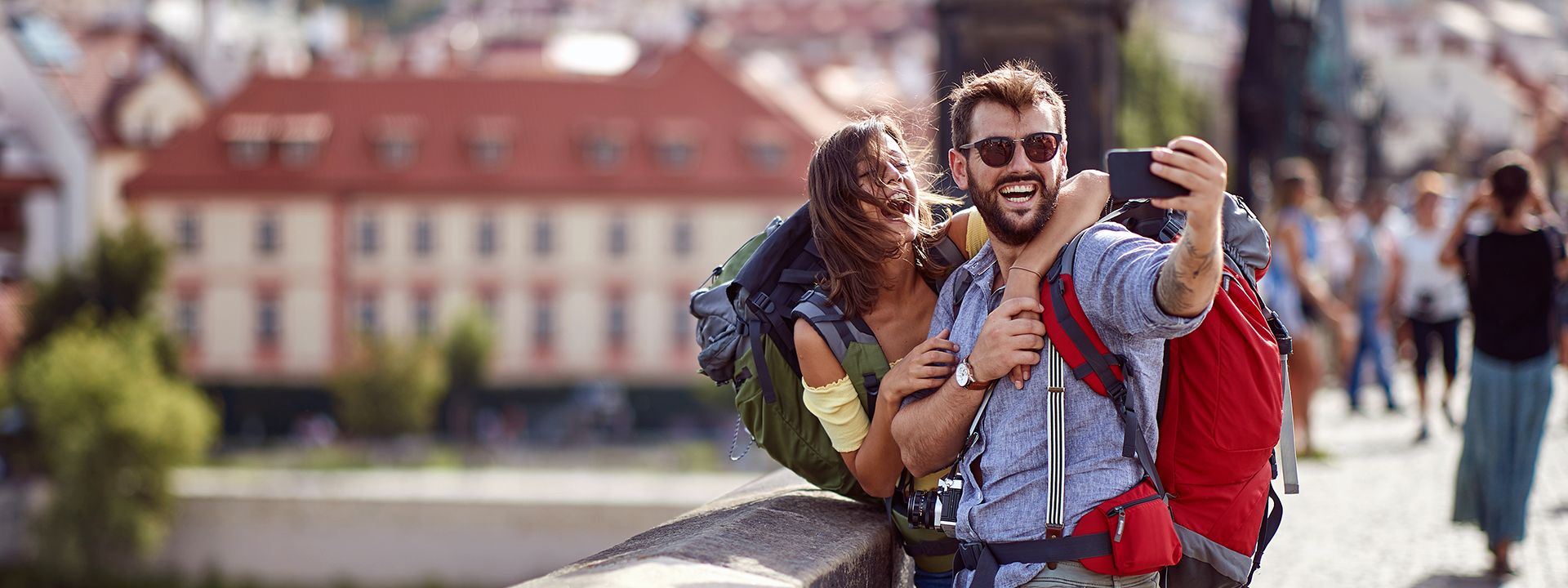 couple with backpacks taking selfie