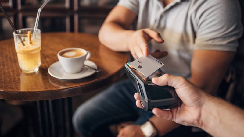 man paying contactless with mobile on a coffee shop